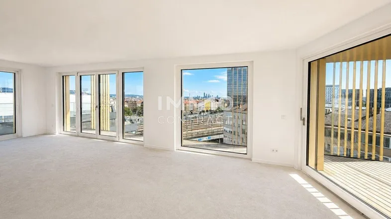 Helles Wohnzimmer mit großen Fenstern, Teppichboden und weitem Stadtblick.