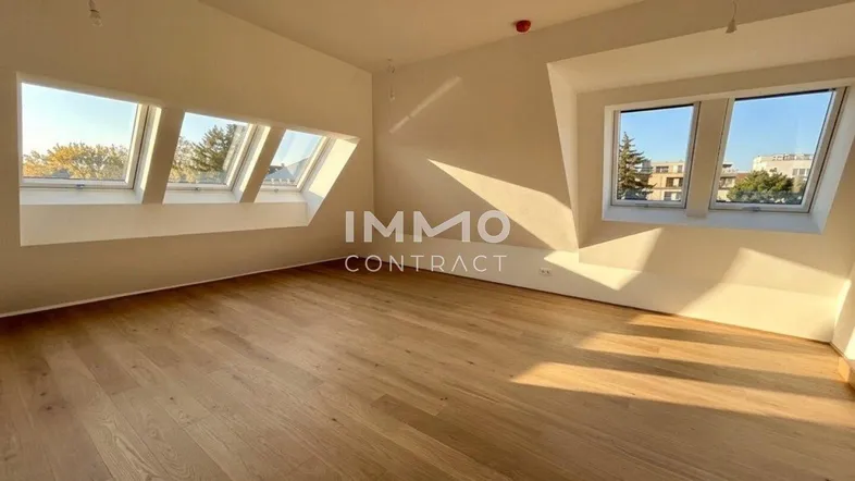 Heller Dachgeschossraum mit Holzboden und mehreren Dachfenstern, ideal für flexible Nutzung.