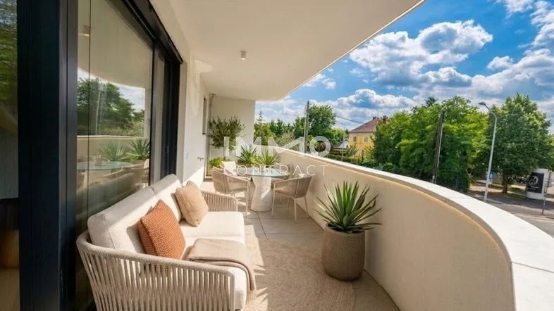 Möblierter Balkon mit bequemen Sitzgelegenheiten und Blick auf die Umgebung unter blauem Himmel.