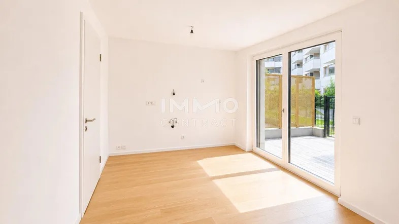 Helles Zimmer mit Holzboden und Zugang zu einer Terrasse, ideal für Wohn- oder Schlafbereich.