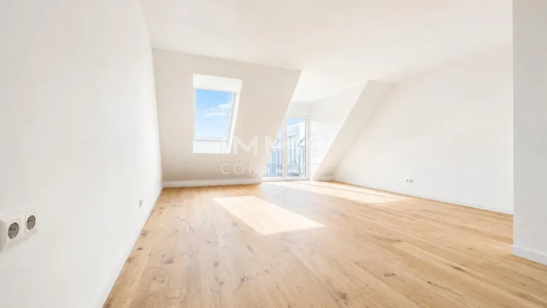 Helles Dachzimmer mit Holzboden und schrägen Wänden, ideal für individuelle Gestaltung und viel Tageslicht.