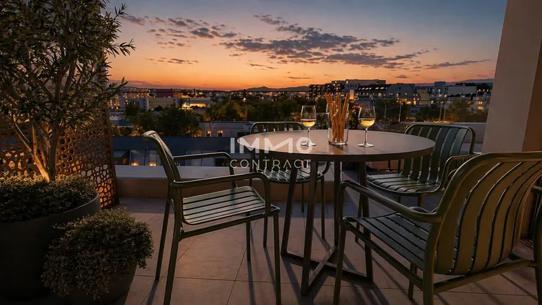 Gemütliche Terrasse mit Sitzgelegenheiten und Blick auf die Stadt bei Sonnenuntergang.