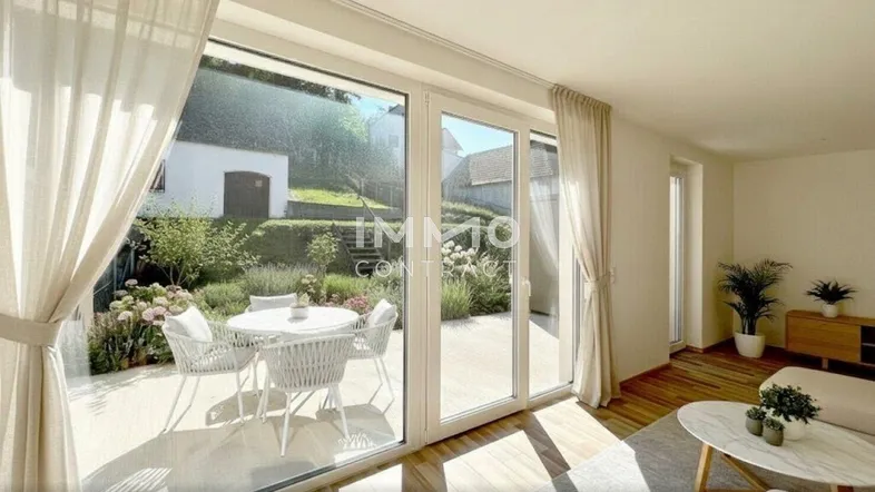 Helles Wohnzimmer mit Holzboden, großen Fenstern und direktem Zugang zu einer möblierten Terrasse mit Gartenblick.