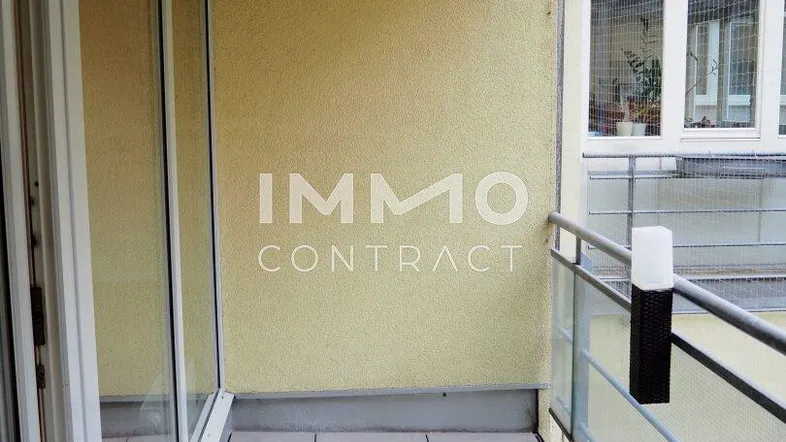 Heller Balkon mit Fliesenboden und Glasgeländer, bietet einen angenehmen Außenbereich.