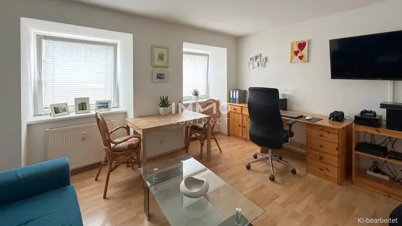 Helles Wohnzimmer mit Holzboden, Esstisch und Arbeitsbereich, ausgestattet mit funktionalen Möbeln.