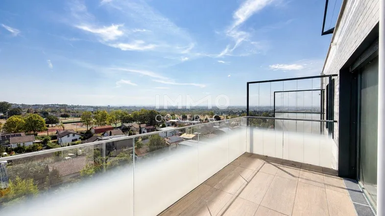 Helles Balkon mit Glasgeländer und weitem Blick über die Landschaft.