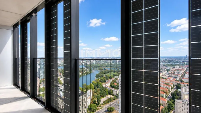 Geräumiger Balkon mit integrierten Solarpaneelen und atemberaubendem Blick über die Stadt und den Fluss.