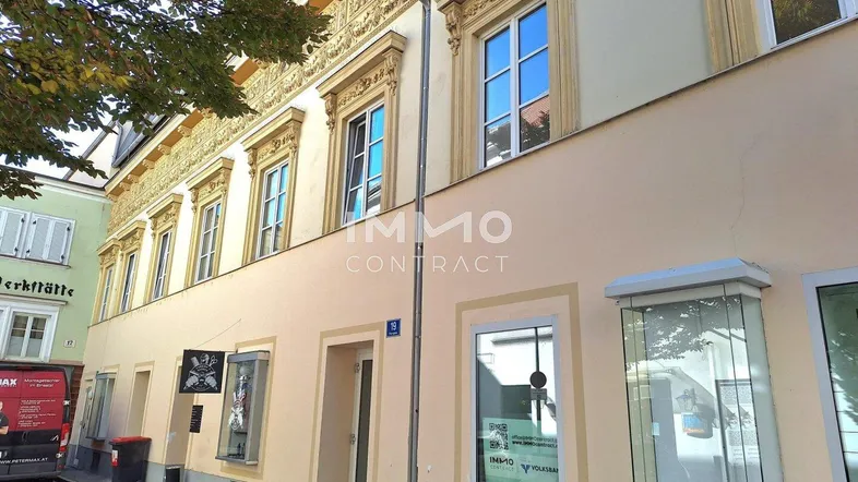 Historisches Gebäude mit klassischer Fassade und dekorativen Elementen an einer städtischen Straße.