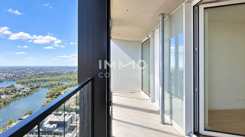 Langer Balkon mit Glasgeländer und weitem Blick über die Stadt und den Fluss.