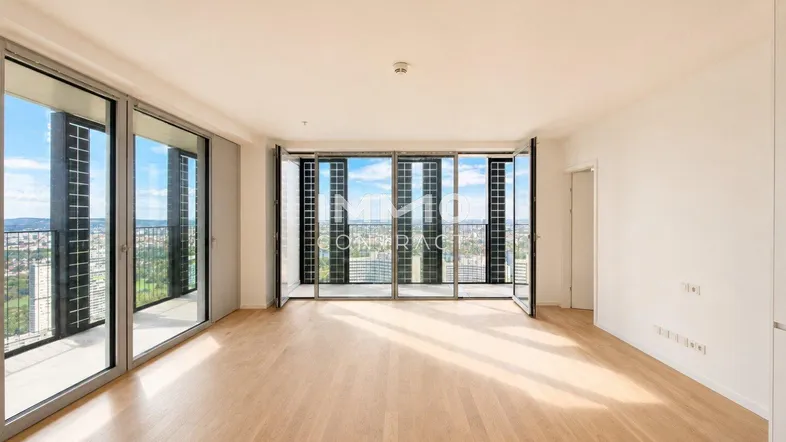 Helles Wohnzimmer mit Holzboden und raumhohen Fenstern, die einen weiten Blick bieten.