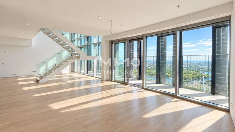 Helles, offenes Wohnzimmer mit Holzboden, moderner Treppe und raumhohen Fenstern mit Stadtblick.