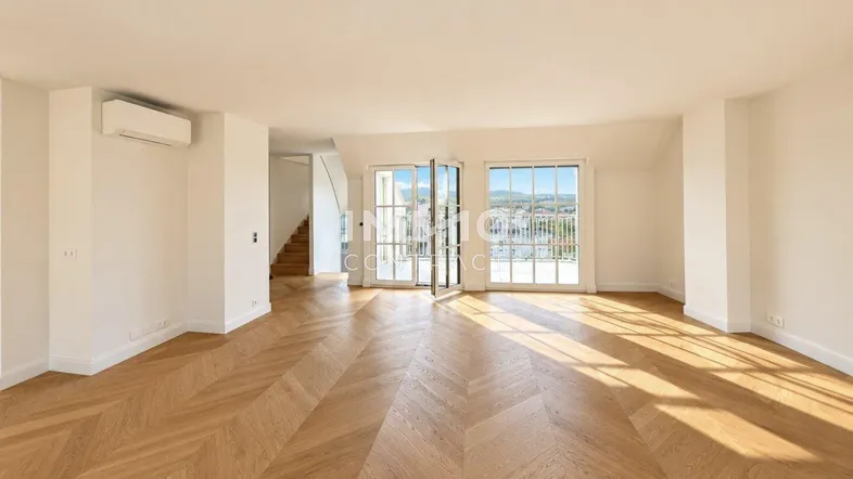 Helles, geräumiges Wohnzimmer mit Fischgrätparkett, Klimaanlage und Zugang zu einem Balkon mit Weitblick.