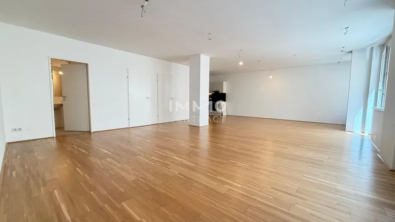 Helles, geräumiges Wohnzimmer mit Parkettboden und weißen Wänden, bereit zur individuellen Gestaltung.