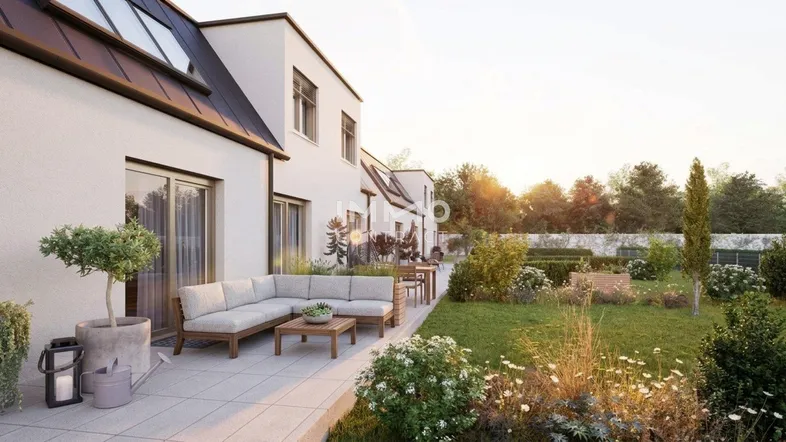 Helle Terrasse mit modernen Gartenmöbeln und Blick auf den gepflegten Garten bei Sonnenuntergang.