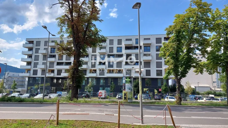 Modernes Wohngebäude mit mehreren Balkonen und umliegender Infrastruktur.
