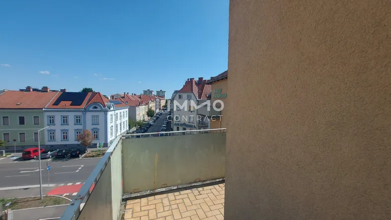 Balkon mit Fliesenboden und weitem Blick über die Stadt und umliegende Straßen.