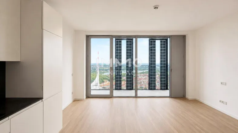 Helles Wohnzimmer mit Holzboden, großen Fenstern und weitem Blick über die Stadt und das Wasser.