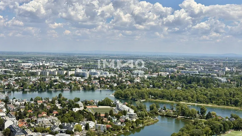 Panoramablick über die Stadt mit Flusslandschaft und Wohngebieten unter blauem Himmel.