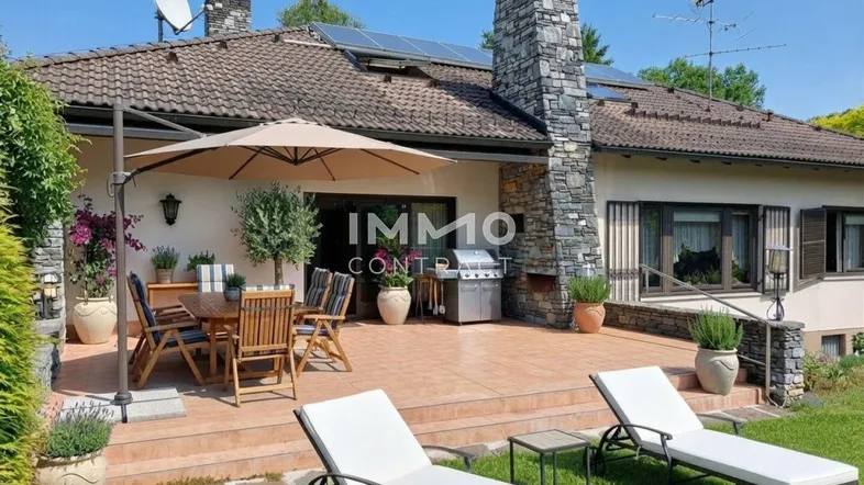 Große Sonnenterrasse mit Gartenmöbeln, Grillbereich und Blick auf den gepflegten Garten.