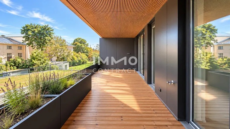 Moderne Holzterrasse mit integrierten Pflanzbeeten und Blick auf die grüne Umgebung.