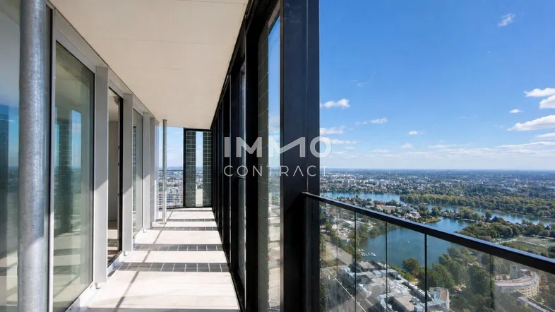 Langer Balkon mit Glasbrüstung und weitem Blick über die Stadt und den Fluss.