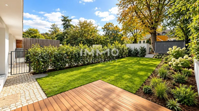 Gepflegter Gartenbereich mit Rasenfläche und Holzterrasse unter blauem Himmel.