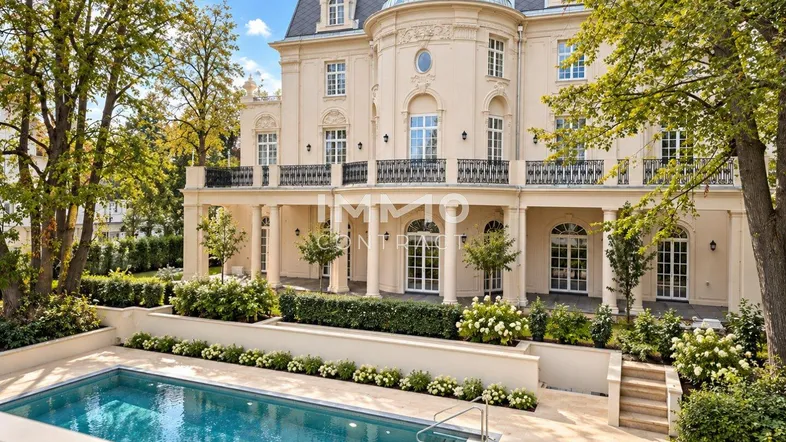 Elegante Villa mit klassischer Architektur, großem Außenpool und gepflegtem Gartenbereich.