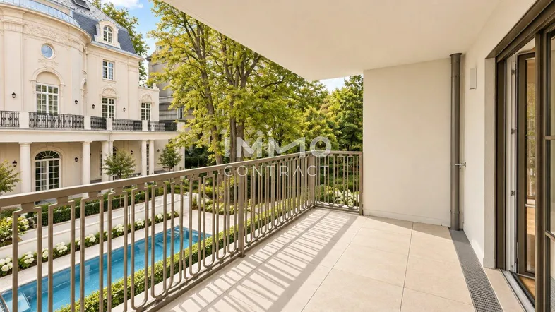 Geräumiger Balkon mit Blick auf einen eleganten Innenhof, einen Pool und grüne Bäume.