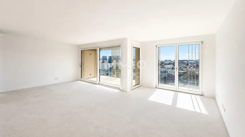 Helles, leeres Zimmer mit großen Fenstern und weitem Blick auf die Stadt.