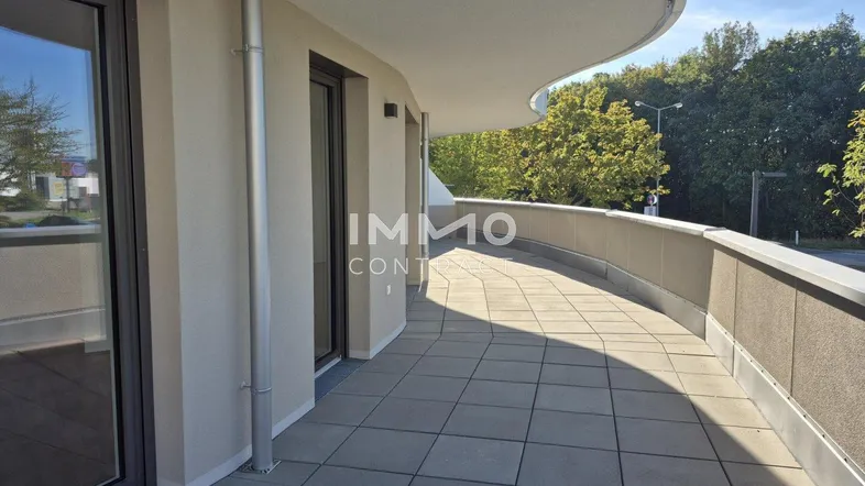 Große, geschwungene Terrasse mit Fliesenboden und weitem Blick ins Grüne.