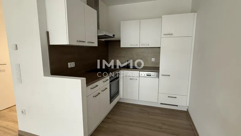 Moderne Einbauküche mit weißen Schränken, Holzoptik-Arbeitsplatte und integrierten Geräten.