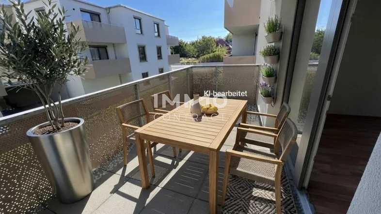 Möblierter Balkon mit Holztisch, Stühlen und Pflanzen, bietet einen angenehmen Außenbereich.