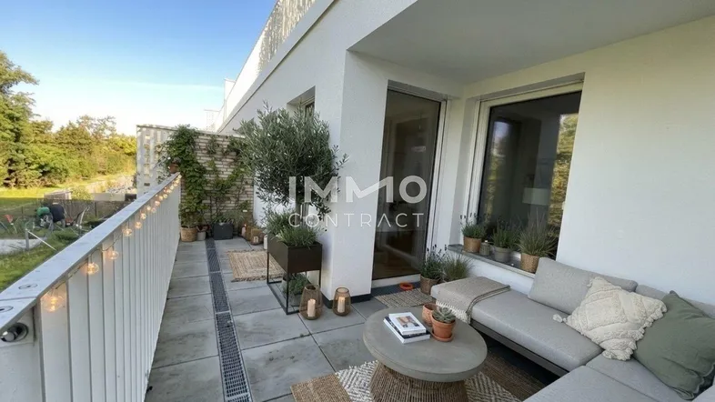 Möblierte Terrasse mit Pflanzen und Sitzgelegenheiten, ideal für entspannte Stunden im Freien.