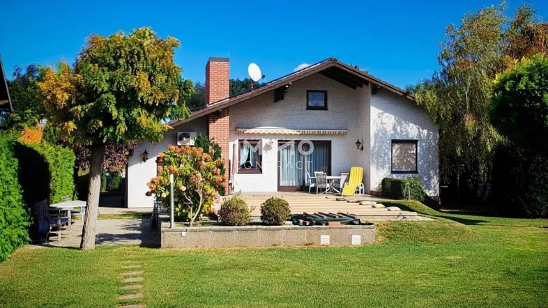 Rückseite des Hauses mit großer Terrasse, Garten und Blick ins Grüne.