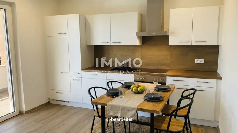 Moderne Einbauküche mit weißen Schränken, Essbereich und Zugang zum Balkon.