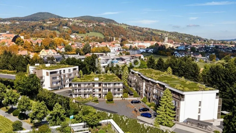 Moderne Wohnanlage mit begrünten Dächern und Blick auf die umliegende Hügellandschaft.