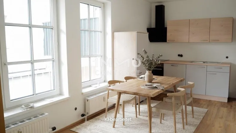 Helle, moderne Küche mit Essbereich, großen Fenstern und Holzboden in einem offenen Raumkonzept.