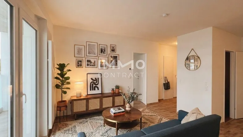 Helles Wohnzimmer mit modernem Sofa, Holzboden, stilvoller Dekoration und Zugang zu einem Außenbereich.
