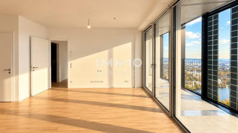 Helles Wohnzimmer mit Parkettboden, großen Fenstern und Zugang zum Balkon mit Stadtblick.