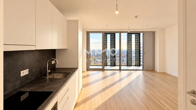 Helle, offene Wohnküche mit modernem Design, Parkettboden und bodentiefen Fenstern mit Stadtblick.