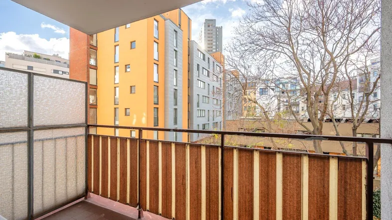 Balkon mit Blick auf umliegende Gebäude und Bäume, ideal für entspannte Stunden im Freien.