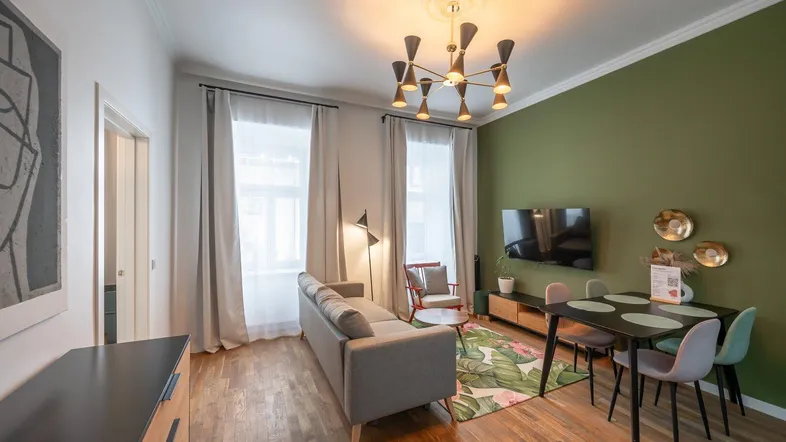 Modernes Wohn- und Esszimmer mit grüner Akzentwand, Holzboden und stilvoller Einrichtung.