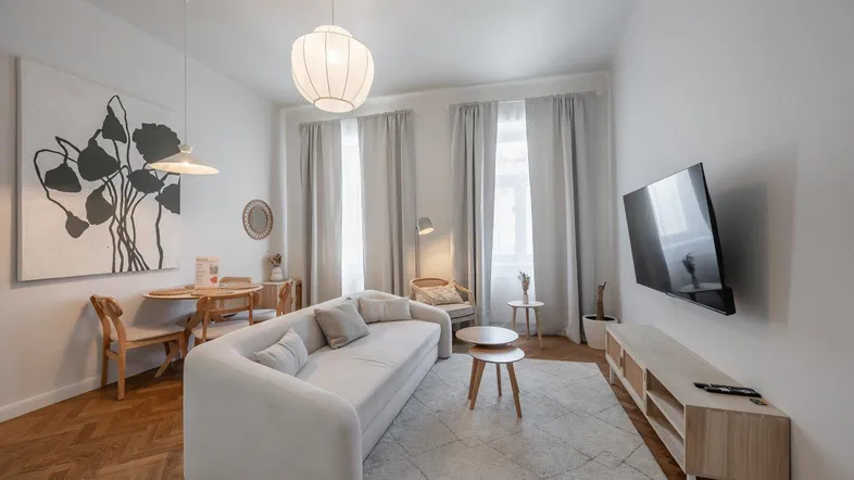 Helles Wohnzimmer mit modernem Sofa, Esstisch und Parkettboden, ideal für entspannte Abende.