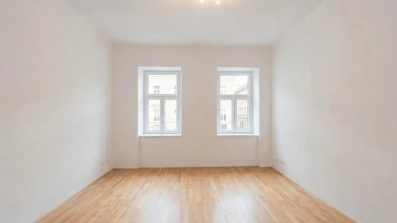 Heller Raum mit Parkettboden und zwei Fenstern, ideal als Wohn- oder Schlafzimmer nutzbar.