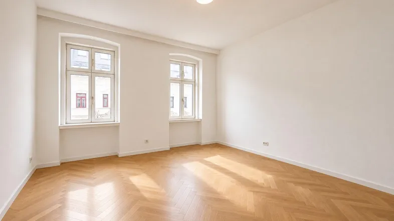 Helles Zimmer mit Fischgrätparkett und weißen Wänden, bereit für die individuelle Gestaltung.