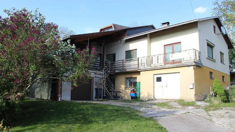 Ansicht des Hauses von außen mit Balkonen, Garagen und einem großen Gartenbereich.