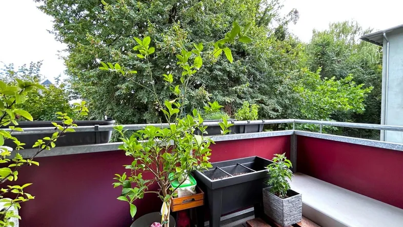 Grüner Balkon mit Pflanzen und Sitzgelegenheit, bietet einen schönen Blick ins Grüne.