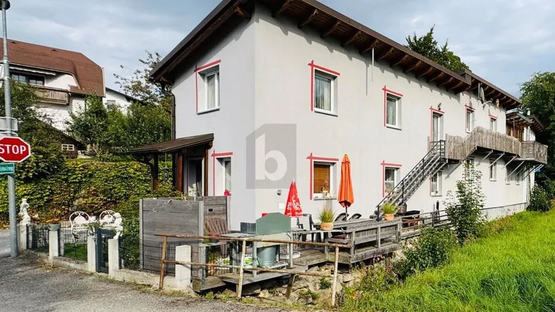 Mehrfamilienhaus mit mehreren Balkonen und Terrassen in ländlicher Umgebung.