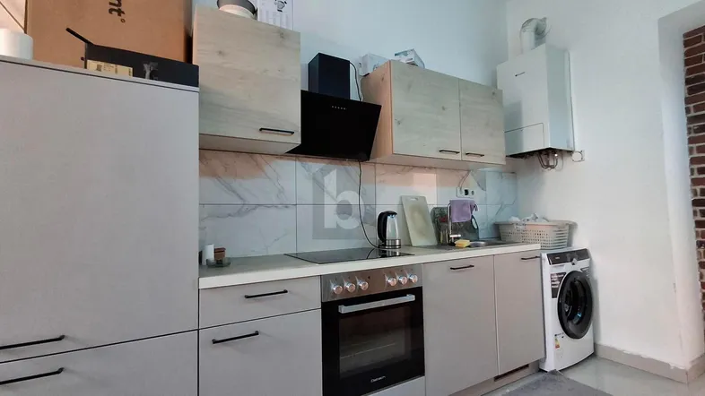 Moderne Küche mit integrierten Geräten, Induktionskochfeld und Waschmaschine unter der Arbeitsplatte.
