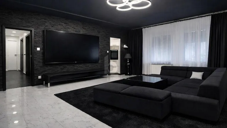 Modernes Wohnzimmer mit dunklen Wänden, großem Fernseher und bequemer Sitzecke.